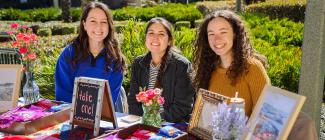 Three females sitting at a booth during an event at the PHSC Spring Hill Campus.